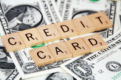 credit card spelled with Uno chips placed on top of paper money