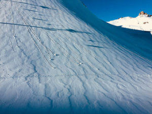 snowballs rolling down a snow covered mountain